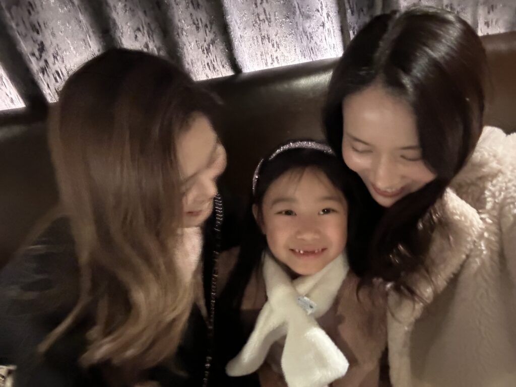A joyful moment shared by a Seoul insider, her 7-year-old daughter, and an American friend, enjoying a sophisticated family dinner in Gangnam