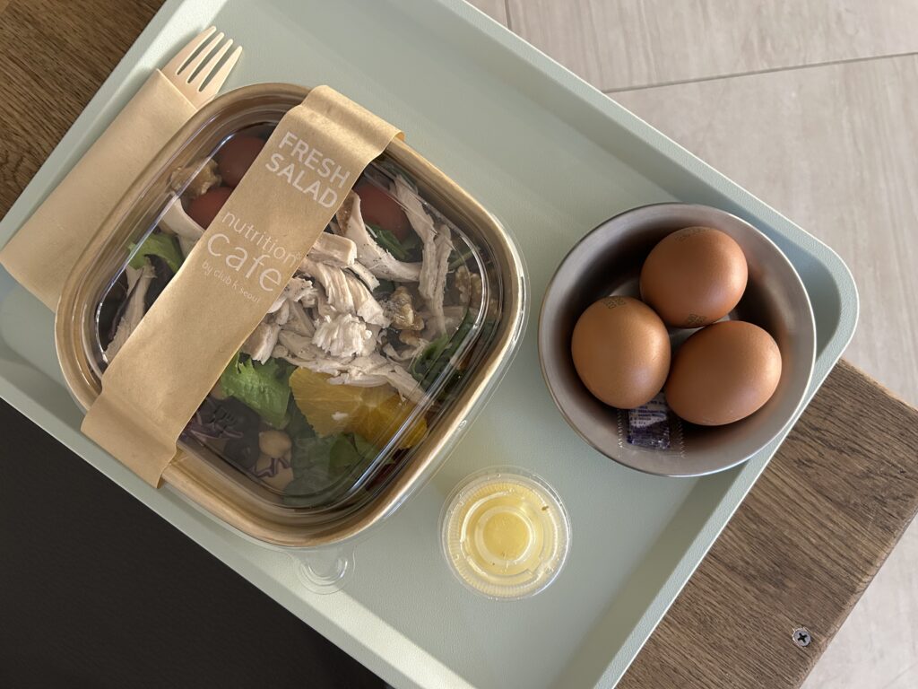 Healthy wellness meal with roasted eggs and salad served in the golden-hued salt room at Club K Seoul, a luxury Korean sauna and Jjimjilbang.