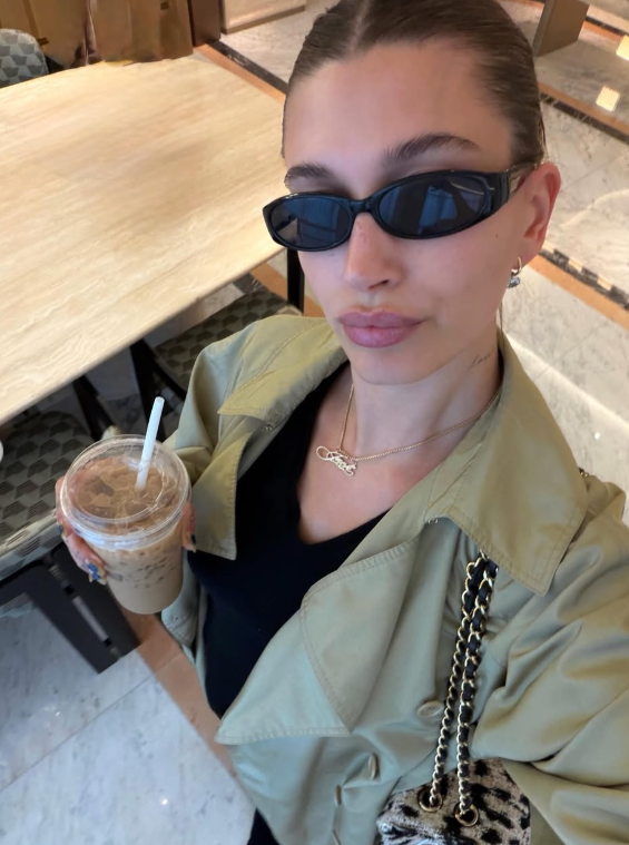 The selfie of Hailey Bieber holding a Ttungba Latte (banana milk latte) in Korea