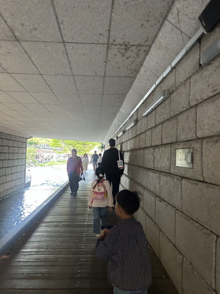 Seoul Travel Guide: Children walking along the stepping stones and refreshing waterfront of Cheonggyecheon Stream in downtown Seoul.