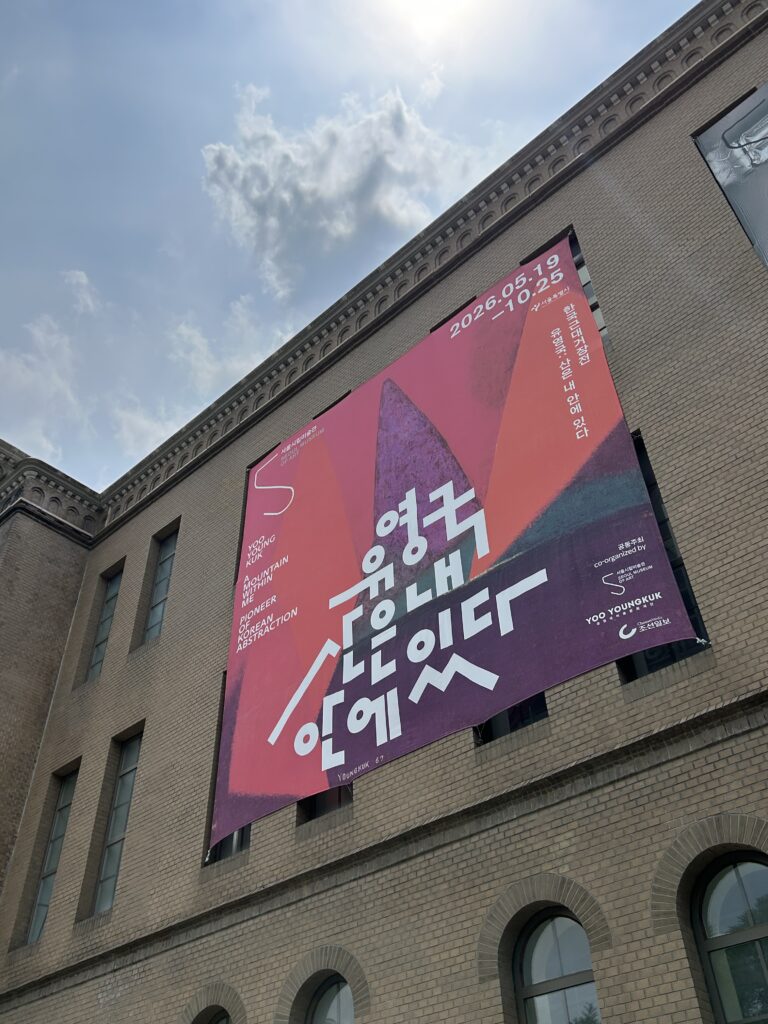 An official poster for the Yoo Youngkuk art exhibition displayed on the white modern wall of the Seoul Museum of Art (SeMA), promoting a top Seoul free exhibition.