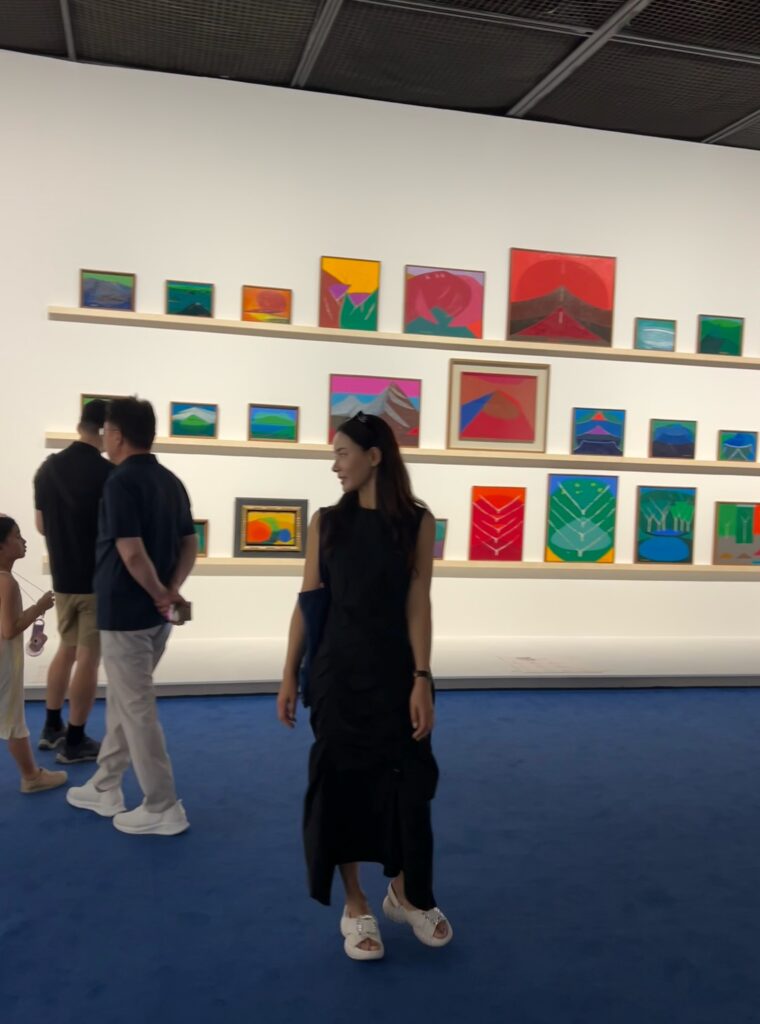 Me standing and posing in front of vibrant abstract paintings by master artist Yoo Youngkuk inside the gallery at this popular Seoul free exhibition.