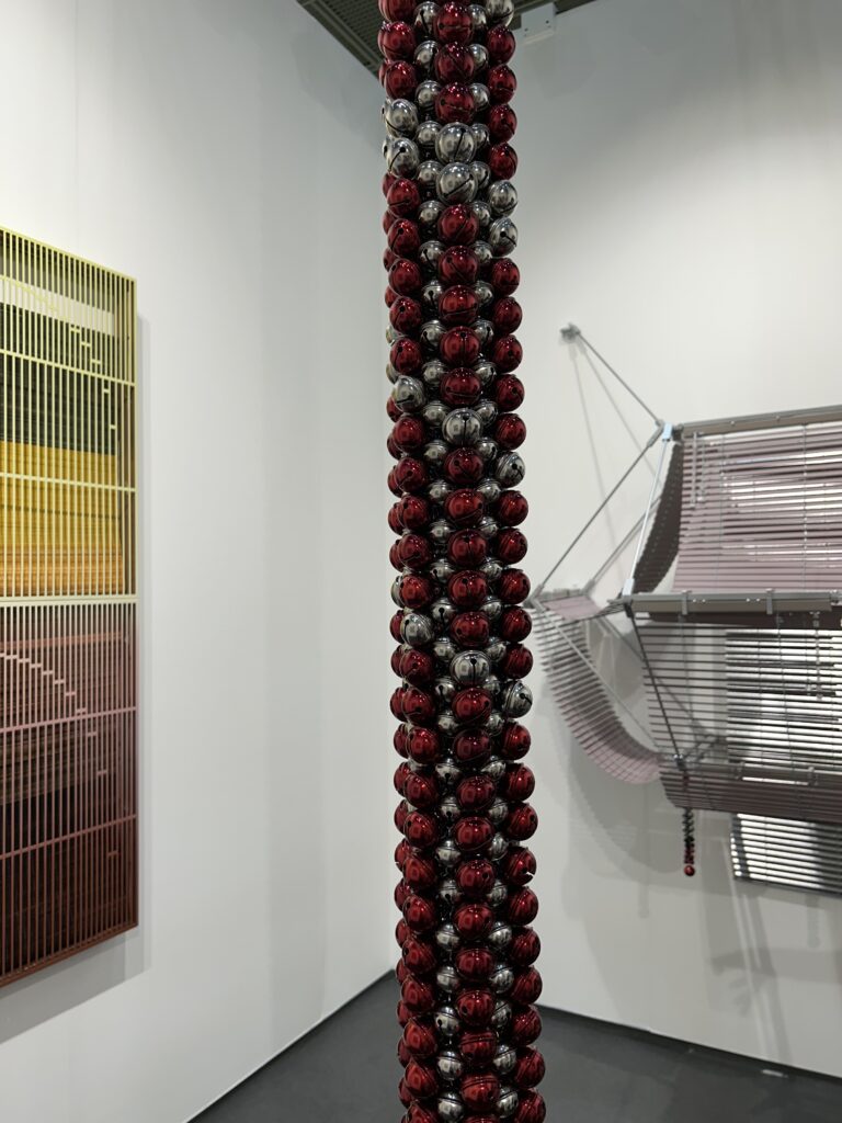 A complex, mixed-media installation art piece using diverse materials like Venetian blinds and metallic bells by Korean conceptual artist Haegue Yang, exhibited at Frieze Seoul 2026.